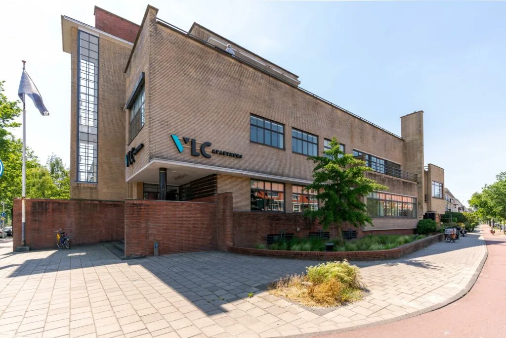 Modern kantoorpand van VLC & Partners aan de Van Alkemadelaan in Den Haag, gefotografeerd op een zonnige dag.